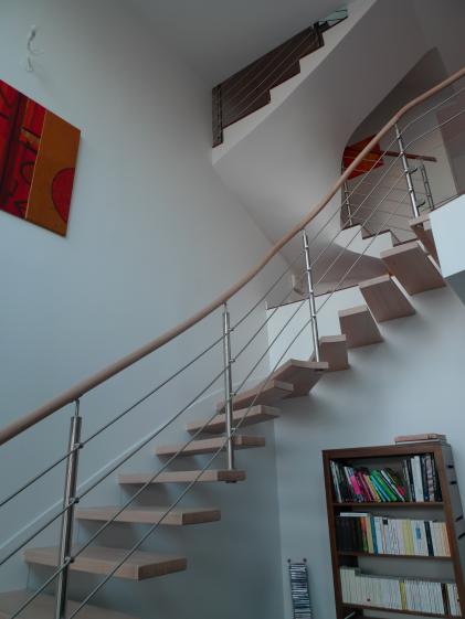 L'escalier aux marches encastrées se developpe dans la double hauteur pour relie