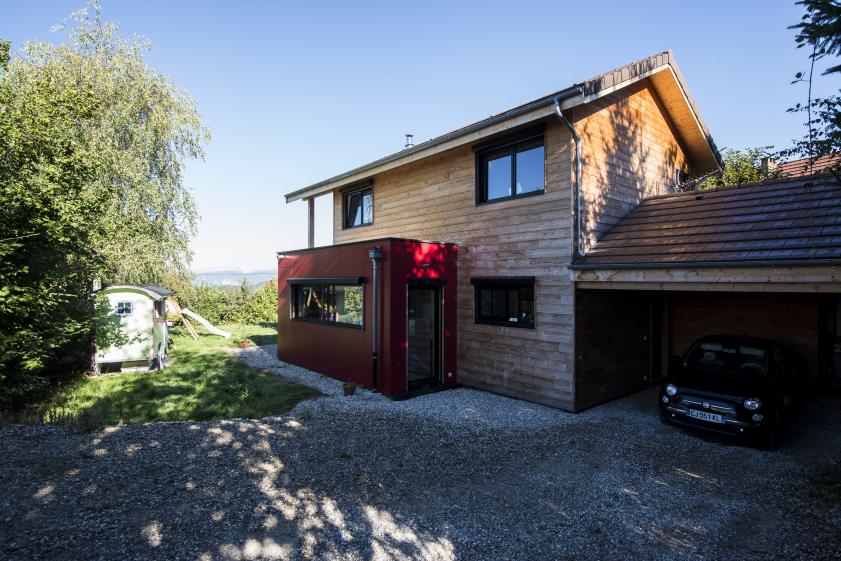 maison en bois, son volume rouge et abri voiture