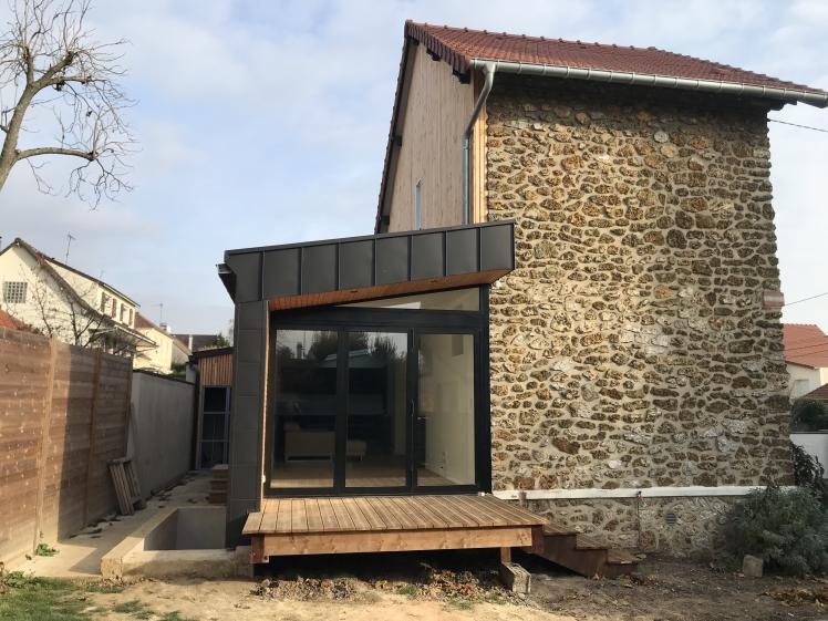 La façade du séjour et la petite terrasse en surplomb de la piscine.