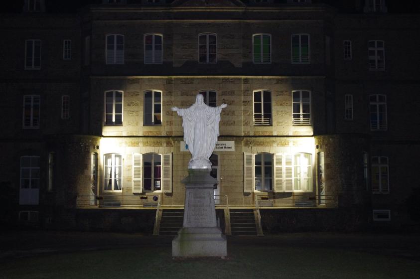 La façade du bâtiment château est mise en valeur par une lumière en pied