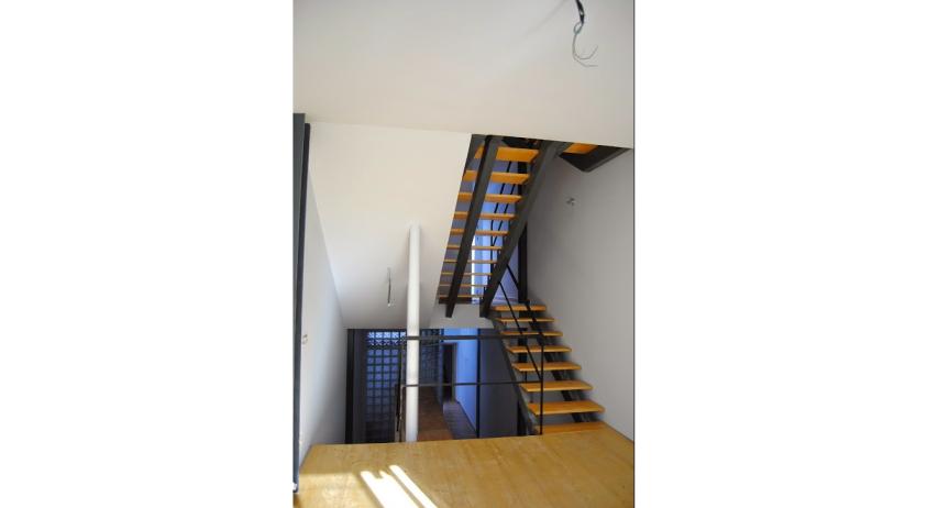 Mezzanine en bois avec escalier en acier et bois.