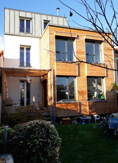 Façade jardin, la maison 1930 est en bardage blanc et l'extension en bardage bru