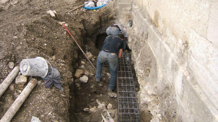 Pose des mocro pieux et des longrines béton sous les fondations de l'église