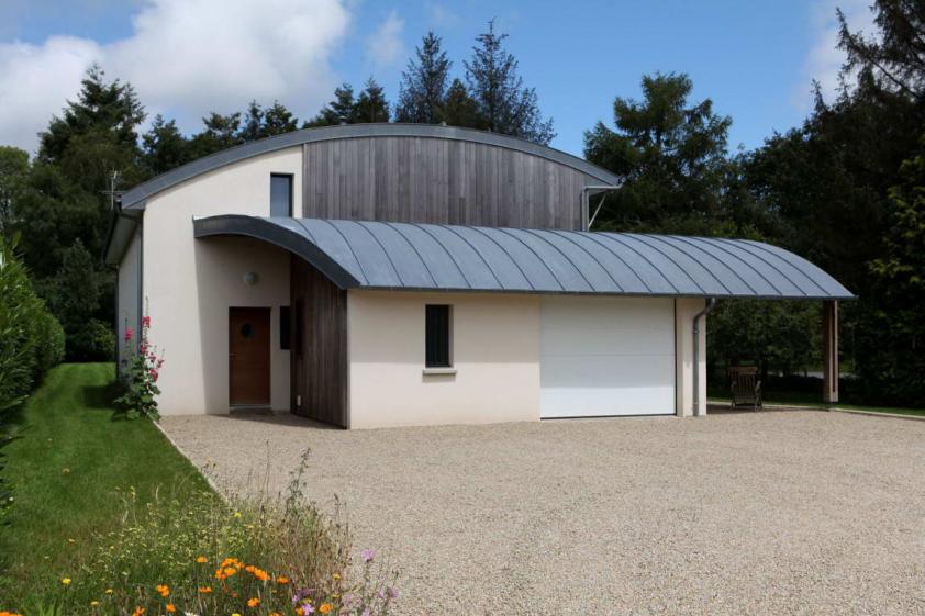 Maison bois bioclimatique, toiture cintrée en zinc à joints debouts