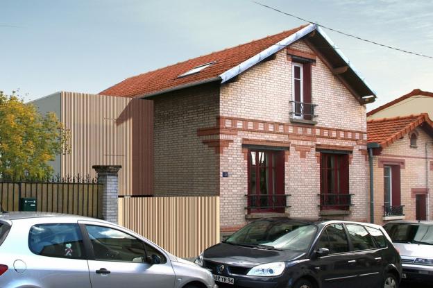 Rue de briques et cube de bois : extension d'une maison existante